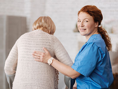 certified nursing assistant helps an elderly patient